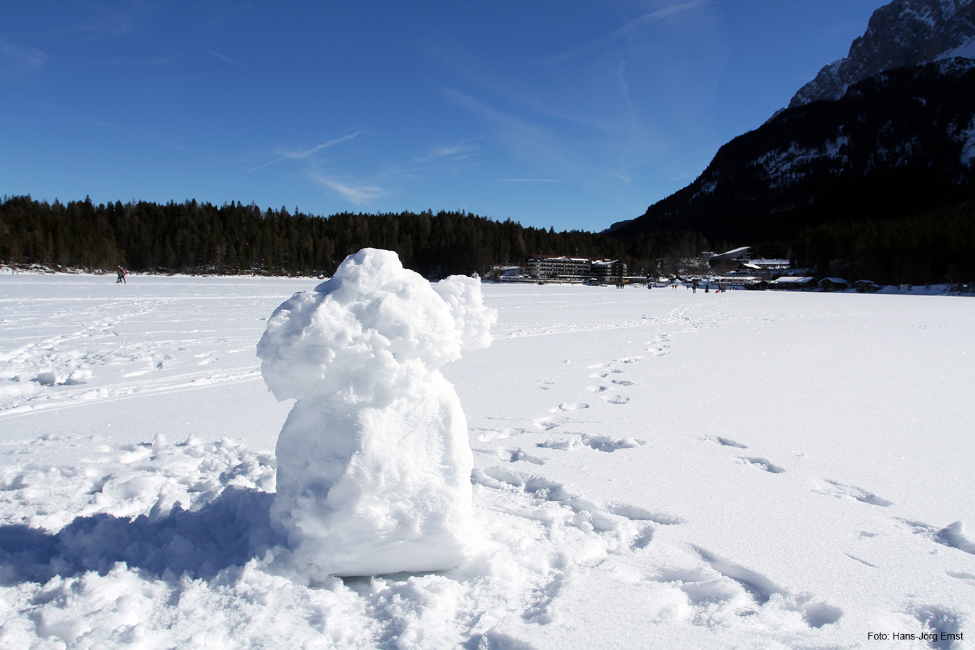MANN IN WEISS Da wo sonst das Wasser grünlich schimmert, steht ein Schneemann und blickt hinüber zum Eibsee-Hotel.